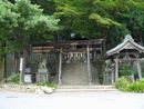 手長神社聖域を示す木製燈篭と石垣、石造狛犬